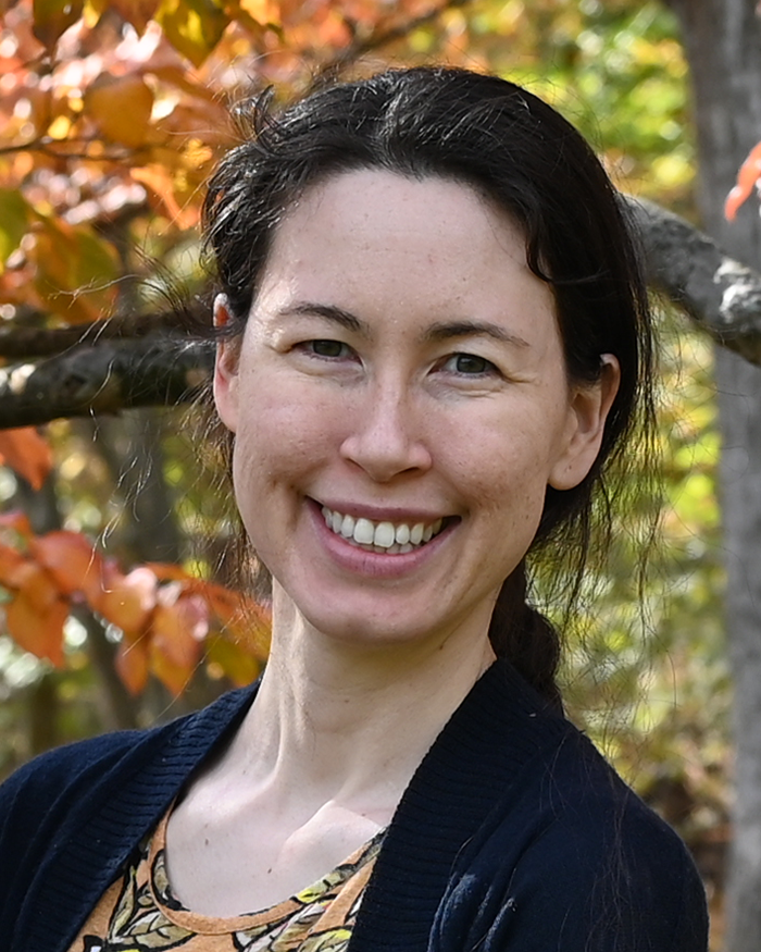 Mayumi Miller smiling with a lovely autumn tree behind her