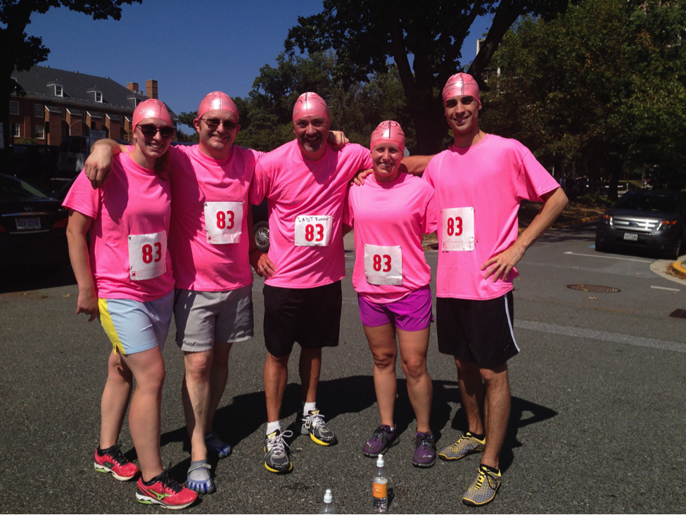 Relay team in pink shirts and skullcaps with a brain design