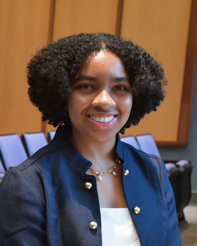 A young Black woman smiling at the camera