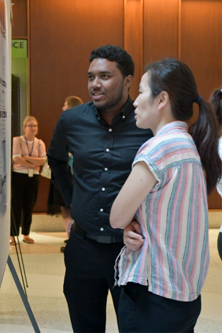 Two fellows chat at the poster session